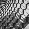Black and white image of a modern building facade with a geometric hexagonal pattern.